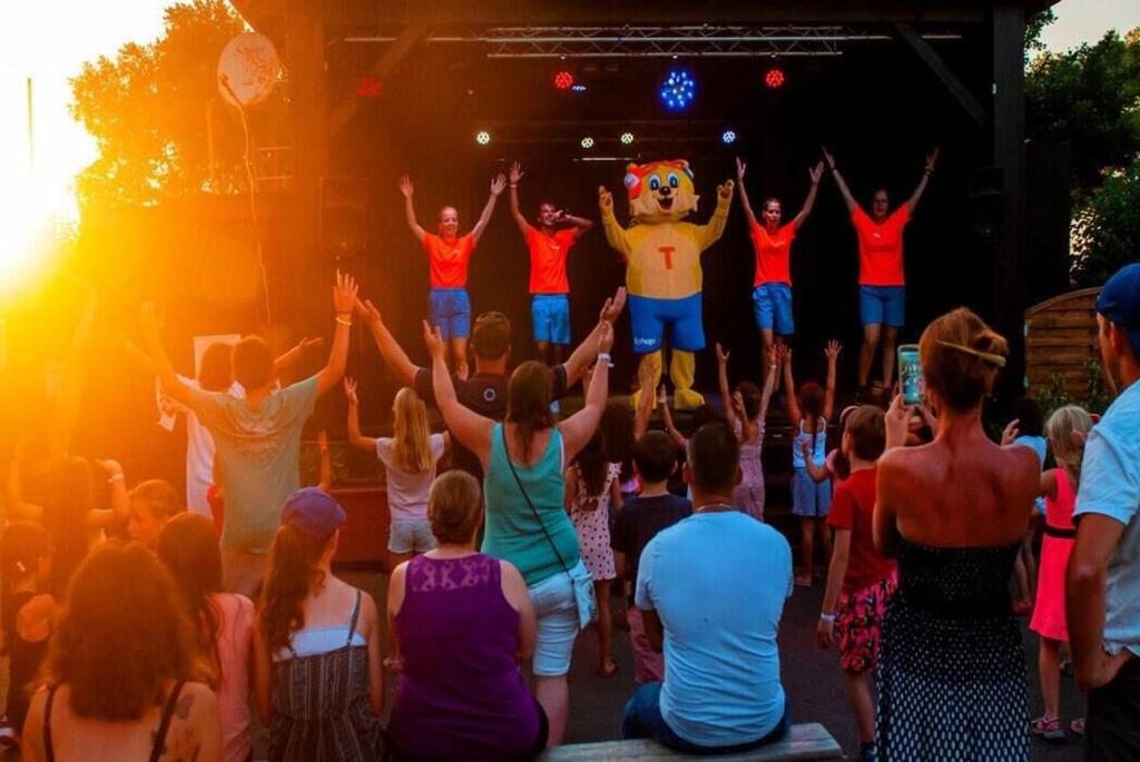 un groupe d’enfants qui assistent à un spectacle sur une scène dans l'établissement Mobil Home du Lac - Camping 4 Étoiles, à Aureilhan