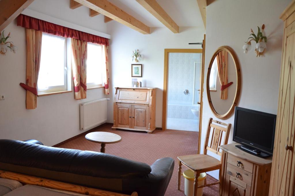 un salon avec un canapé et un miroir dans l'établissement Alpenlandhotel Rodeneggerhof, à Rodengo