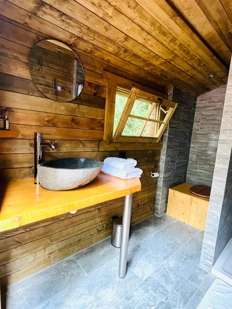 La salle de bains est pourvue d'un lavabo sur un mur en bois. dans l'établissement Aux Étangs de Jourgnac - Yourte, à Jourgnac 3 autres photos