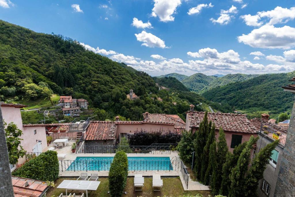 un complexe avec une piscine dans les montagnes dans l'établissement Palazzo Giusti, Understated Luxury with a Welcoming Ambience on the Hills of Lucca, à Pescaglia