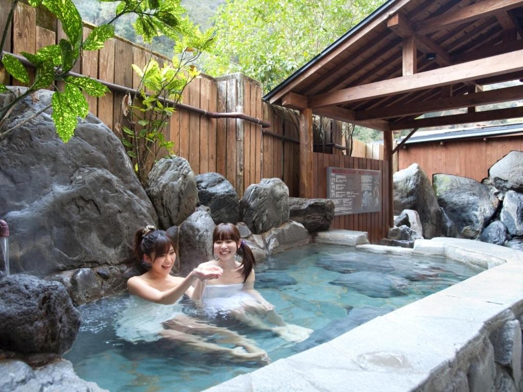 Deux filles dans un bain à remous avec un ours polaire dans l'établissement Tsuetate Onsen Hotel Hizenya, à Oguni