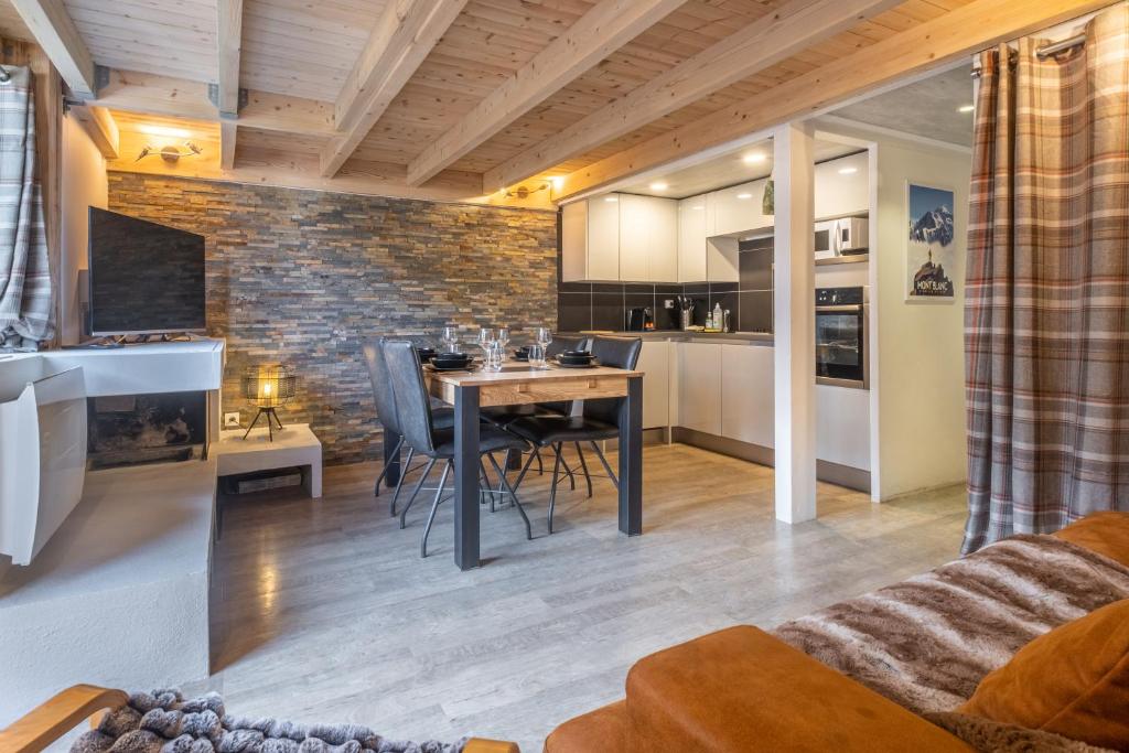 une cuisine et un salon avec une table et des chaises dans l'établissement Grand Roc A - 3 bedrooms Apartment Next to skilift - By Cozee Rentals, à Chamonix-Mont-Blanc 19 autres photos