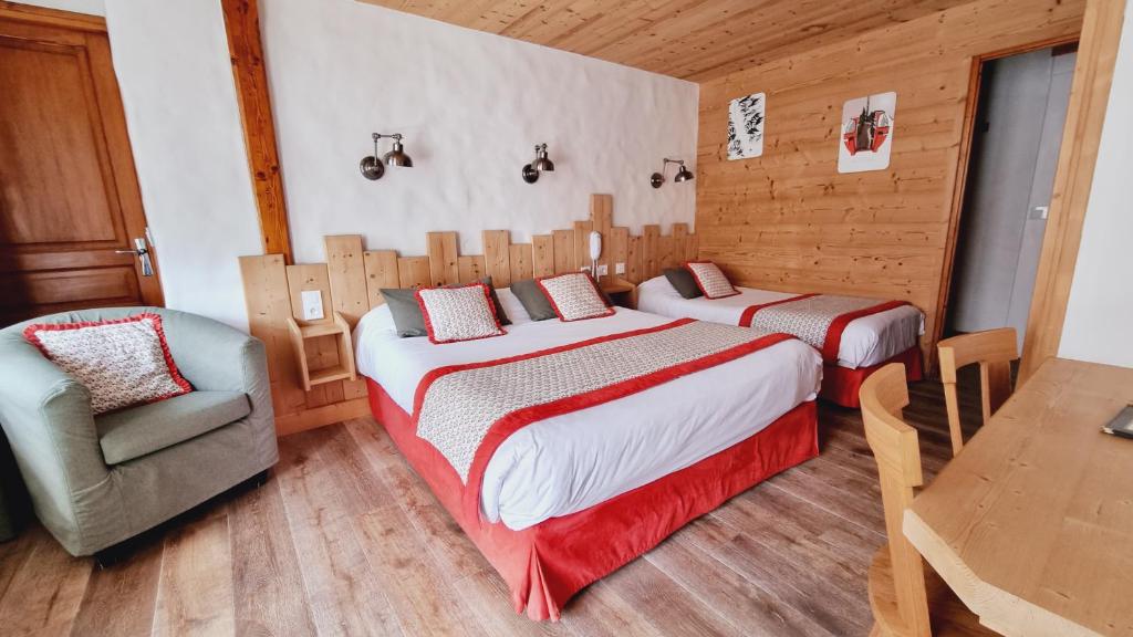 - une chambre avec deux lits, une chaise et une table dans l'établissement Hôtel Le Sporting, à Morzine