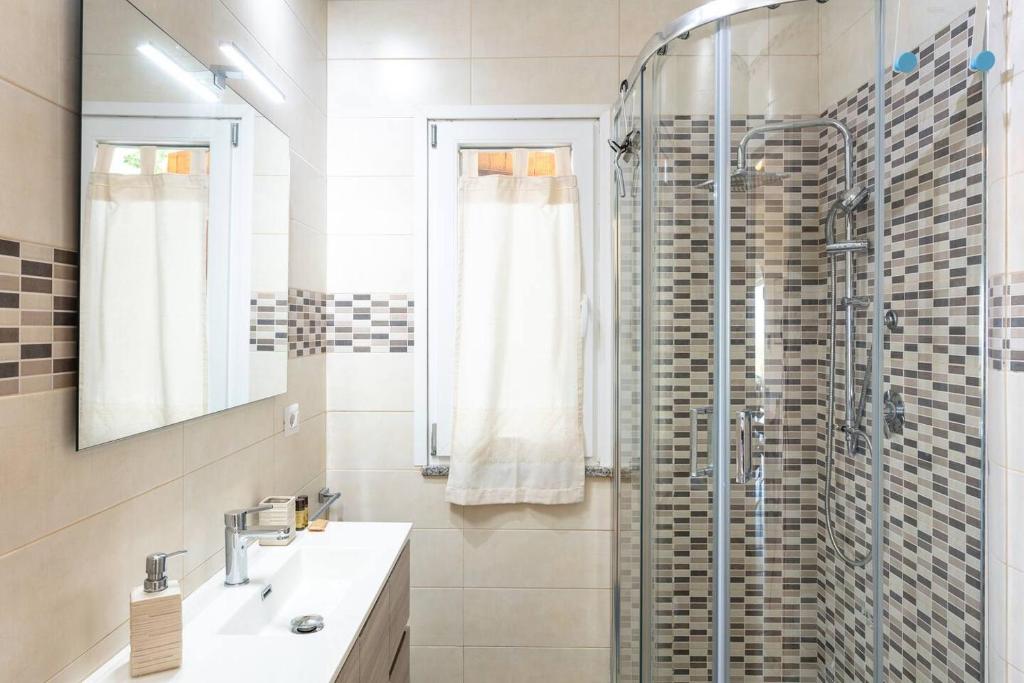 une salle de bain avec une douche, un lavabo et un miroir dans l'établissement Villa Lara, à Cugnana 19 autres photos