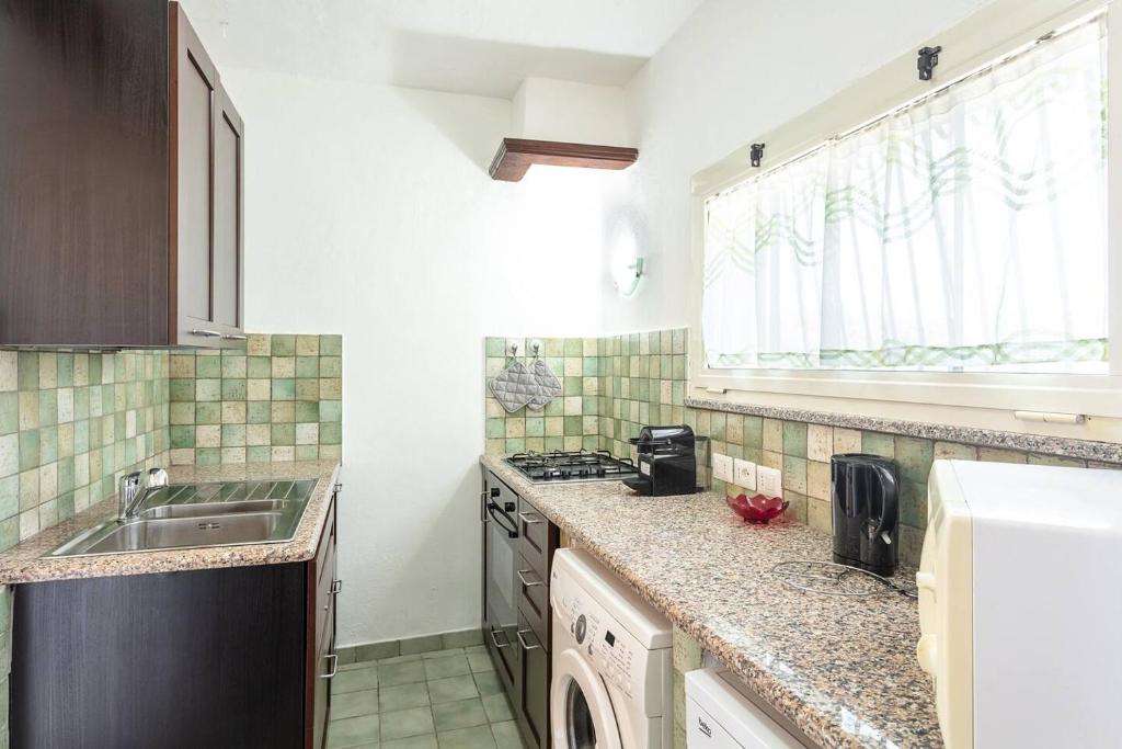 une cuisine avec un évier et un plan de travail dans l'établissement Villa Lara, à Cugnana