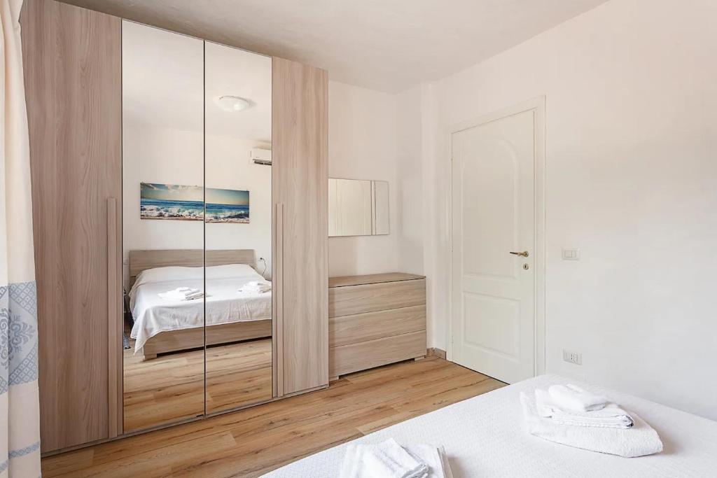 - une chambre avec un grand placard en verre et un lit dans l'établissement Villa Lara, à Cugnana