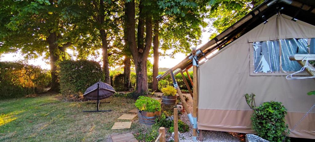 une tente dans une cour à côté de quelques arbres dans l'établissement Tente lodge la Flavignienne, à Flavigny-sur-Ozerain