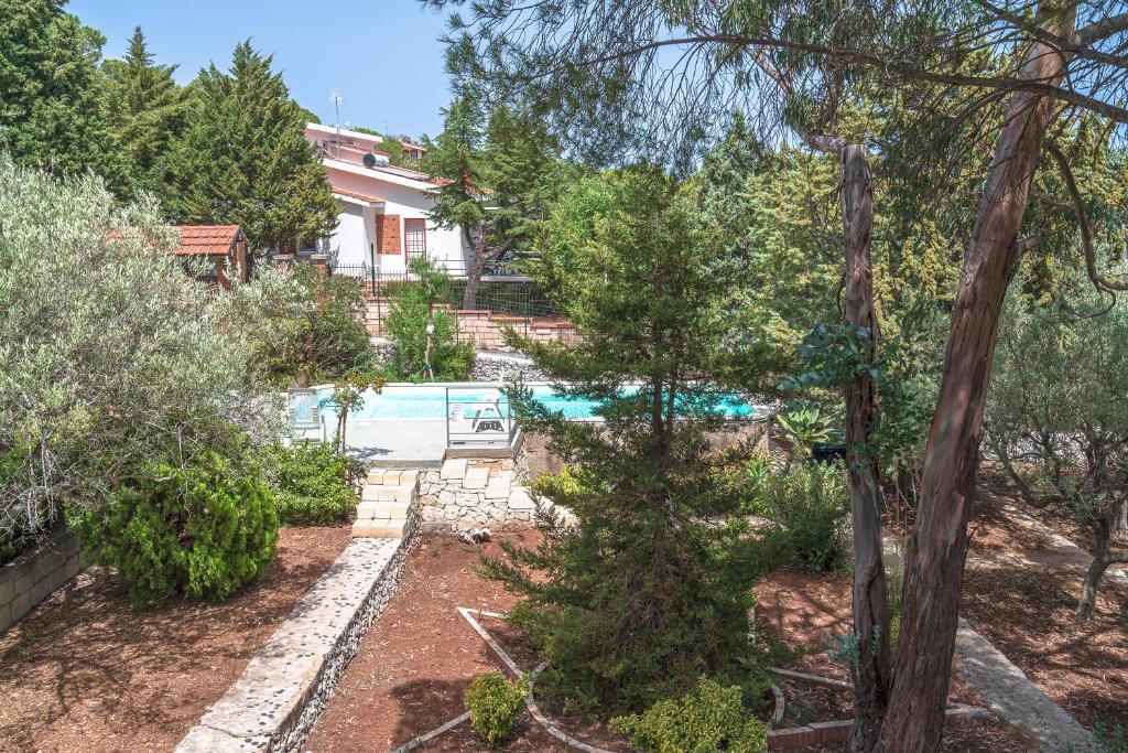 un jardin avec une piscine et une maison dans l'établissement Gli Ulivi, à Avola