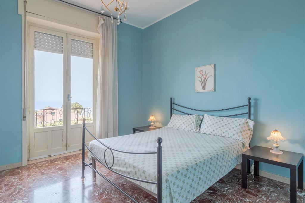 - une chambre bleue avec un lit et un balcon dans l'établissement Gli Ulivi, à Avola