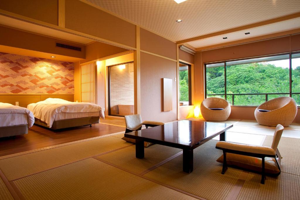 une chambre avec un lit, une table et des chaises dans l'établissement Hanashinsui, à Toba