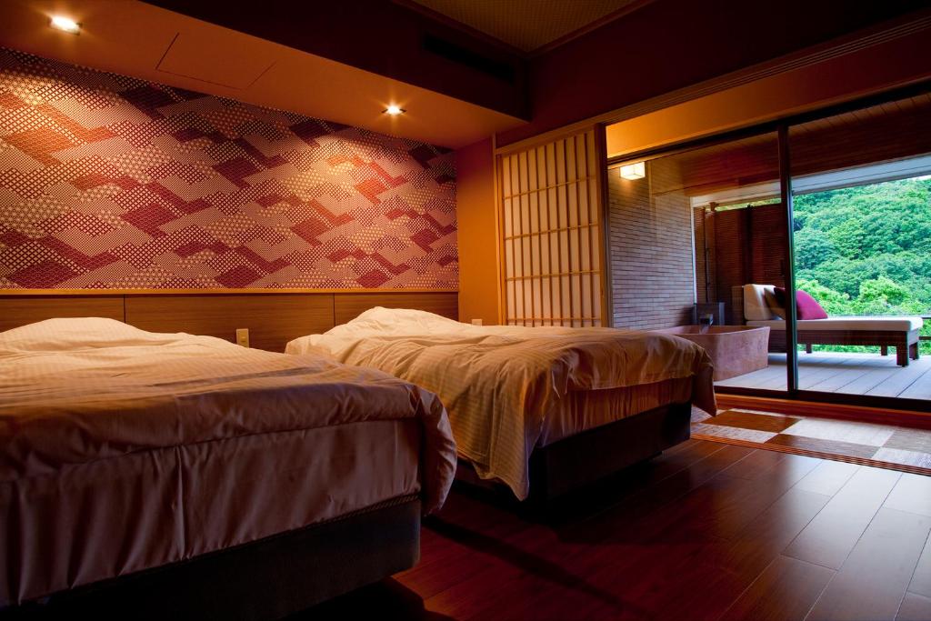 une chambre d'hôtel avec deux lits et une fenêtre dans l'établissement Hanashinsui, à Toba