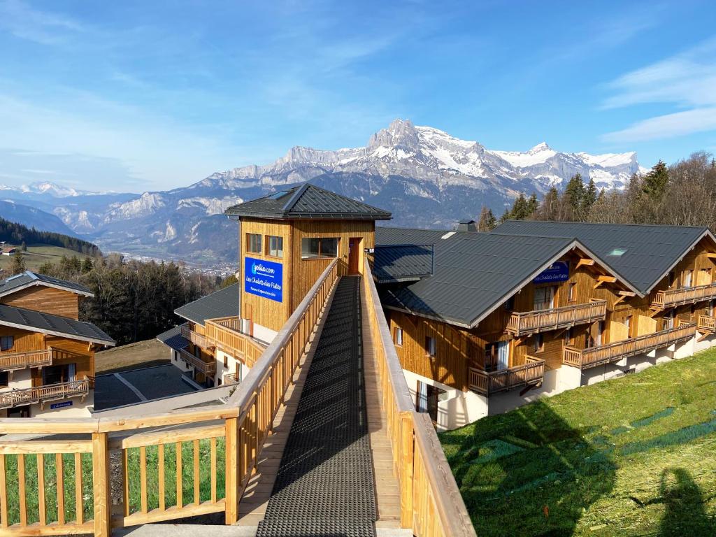 - une vue sur un lodge avec des montagnes en arrière-plan dans l'établissement Goélia Les Chalets des Pistes, à Combloux