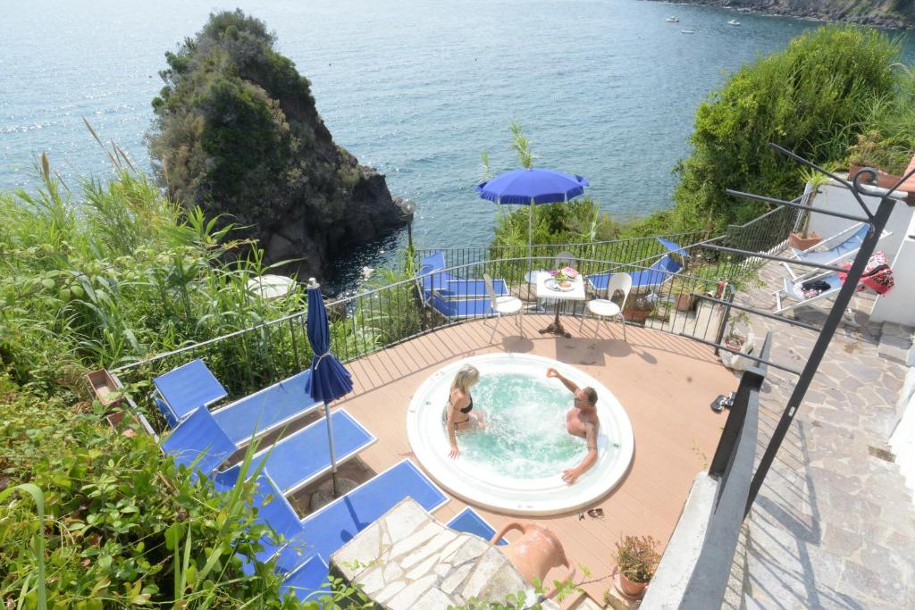 un couple de personnes dans une piscine au bord de l'eau dans l'établissement Hotel La Ninfea, à Ischia