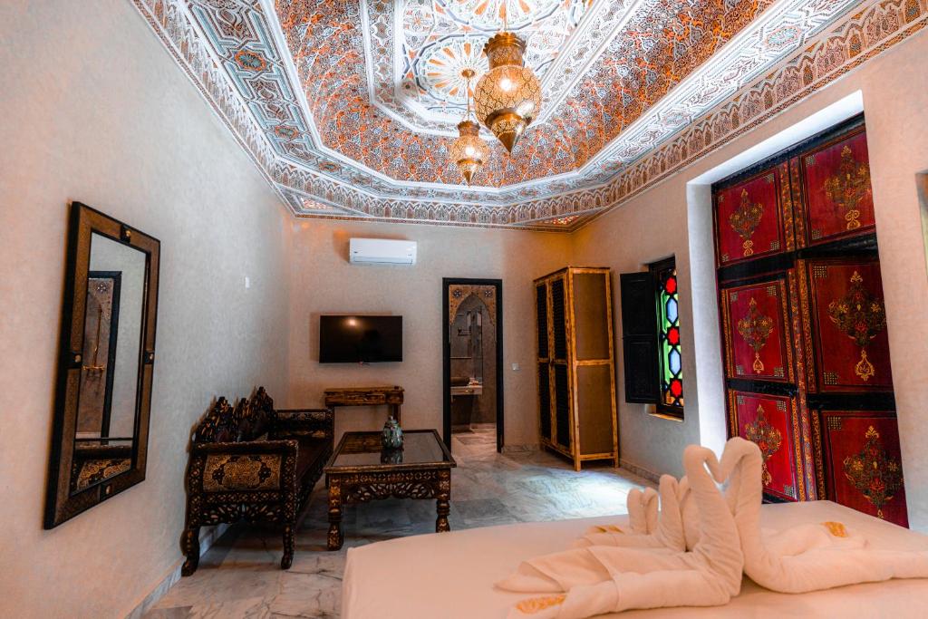 un salon avec un plafond à caissons et une chambre avec un canapé dans l'établissement Riad Deluxe, à Marrakech