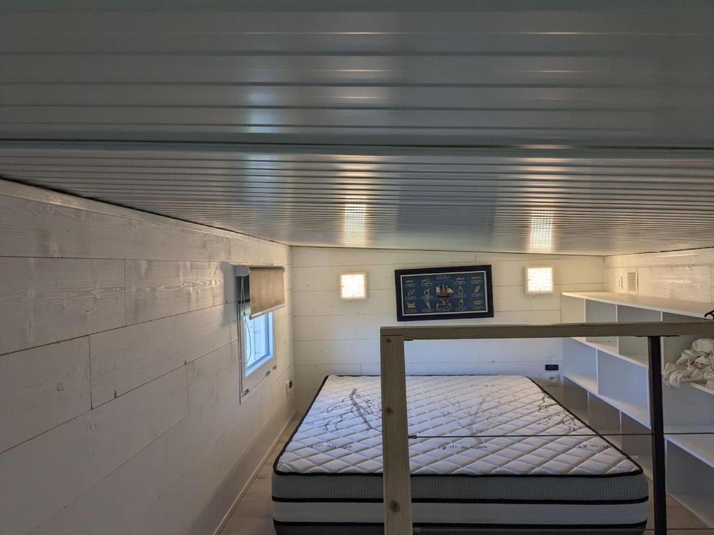 Cette petite chambre dispose d'un lit au plafond. dans l'établissement Tiny House proche de la plage sans draps ni serviettes, à Plévenon 5 autres photos