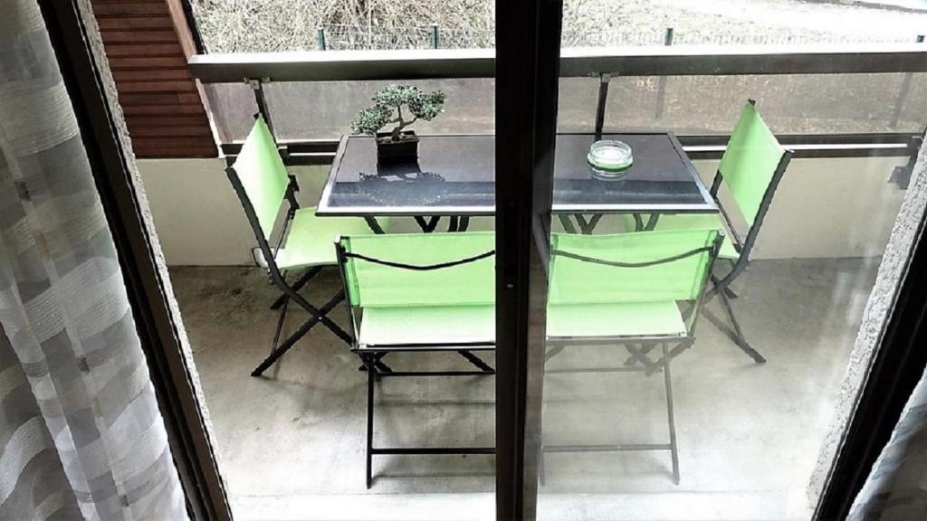 une table et des chaises assises sur un balcon dans l'établissement Charmant T2, hypercentre, calme, terrasse, parking, à Luchon