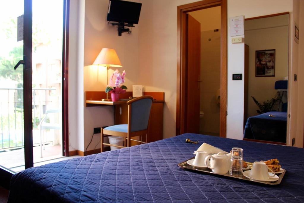 Cette chambre comprend un lit bleu et un plateau/bouilloire. dans l'établissement Arcangelo Roof Hotel, à Rimini