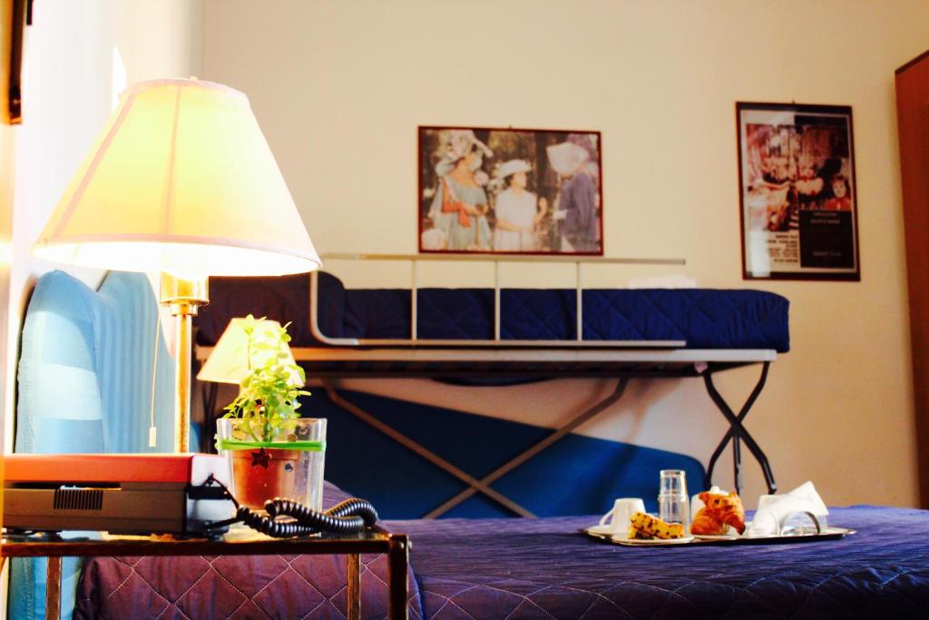 une table avec une lampe et une assiette de nourriture dessus dans l'établissement Arcangelo Roof Hotel, à Rimini