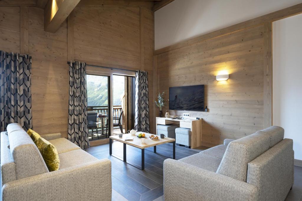 un salon avec deux canapés et une table dans l'établissement MGM Hôtels & Résidences - Hôtel Alpen Lodge, à La Rosière