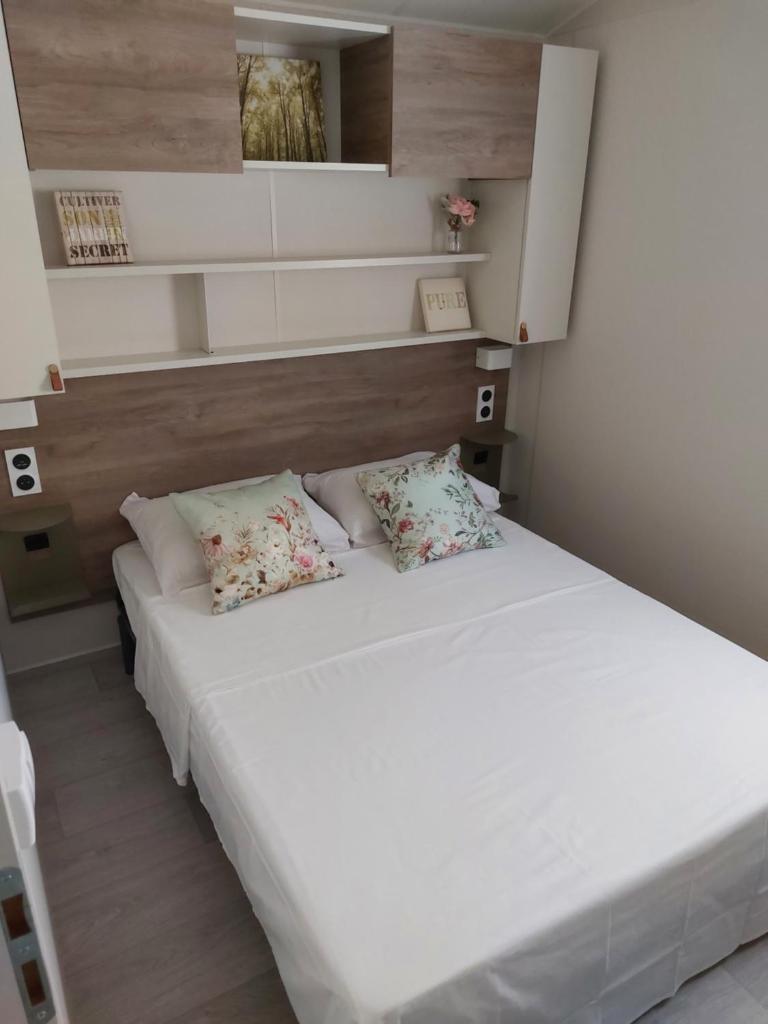 une chambre avec un grand lit blanc avec deux oreillers dans l'établissement L'arbre perché, à Saint-Raphaël