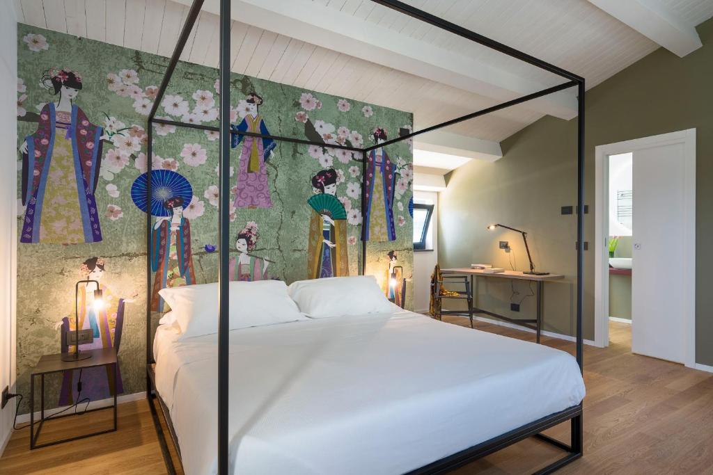 une chambre avec un lit blanc avec un tableau sur le mur dans l'établissement Gianos Villa, à Mascali