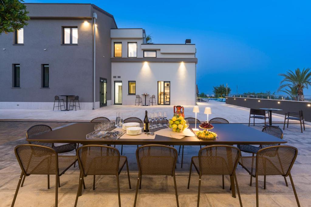 une table à manger et des chaises en face d'une maison dans l'établissement Gianos Villa, à Mascali
