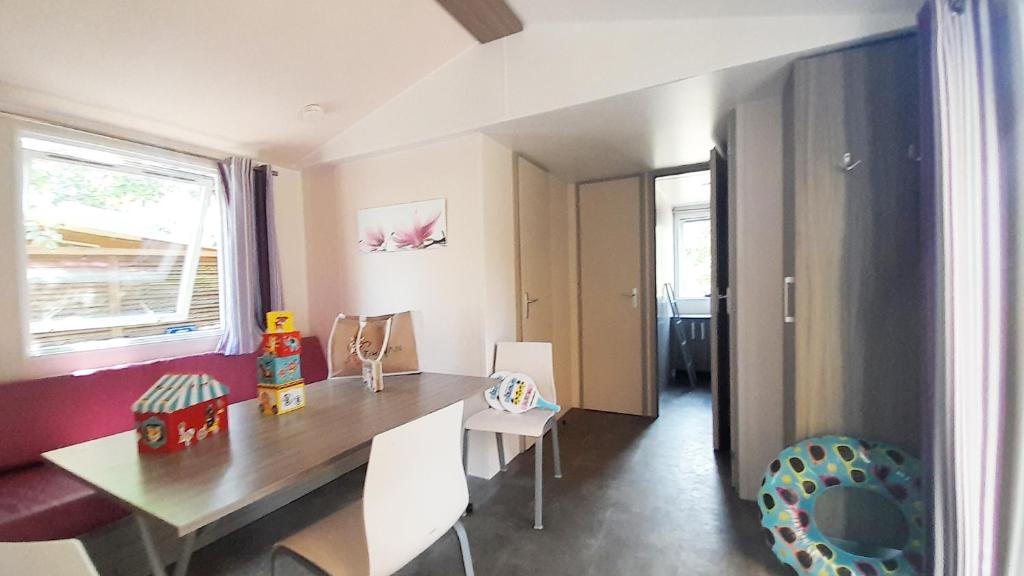 une salle à manger avec une table et des chaises en bois dans l'établissement Camping Tikayan La Célestine, à Beynes 37 autres photos