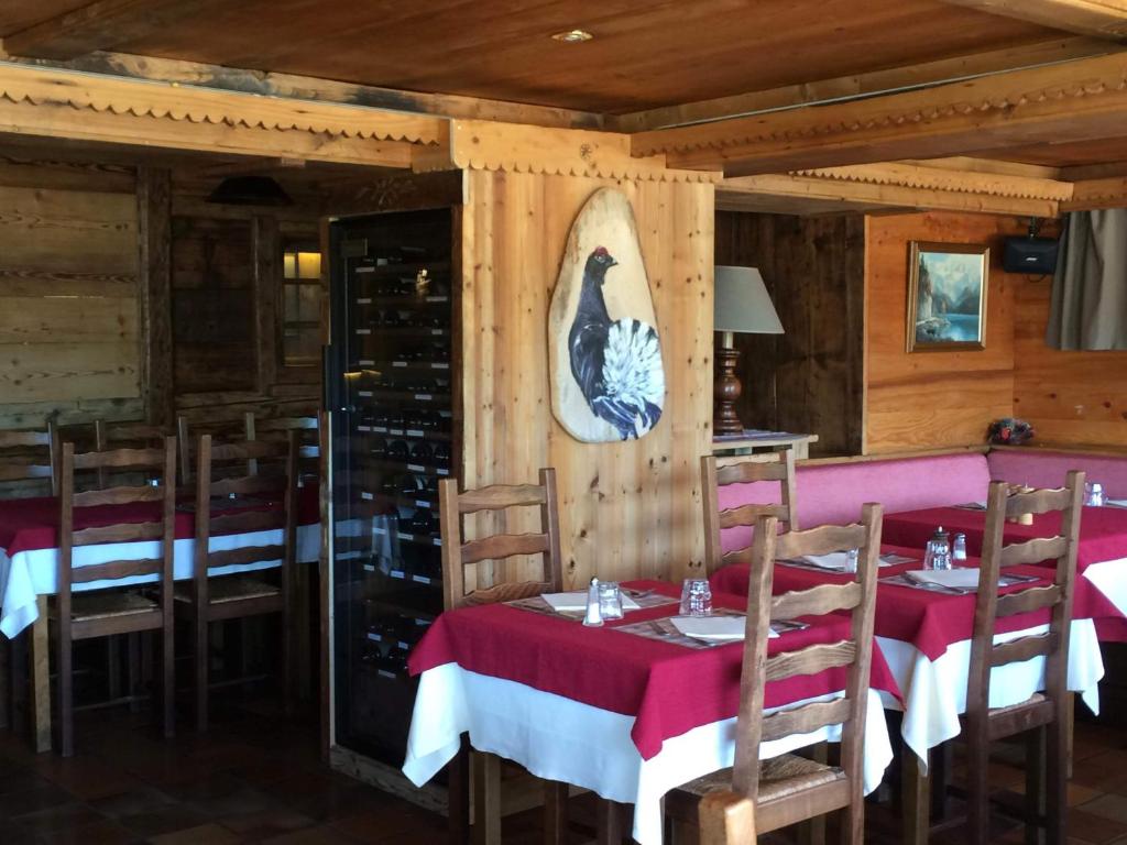 une salle à manger avec des tables et des chaises dans un restaurant dans l'établissement Hotel Le Tetras, à Notre-Dame-de-Bellecombe
