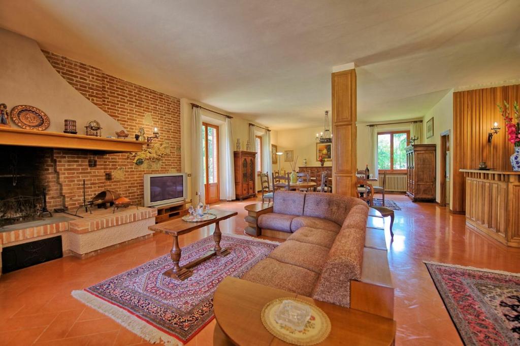 un salon avec un canapé et une cheminée dans l'établissement Villa Lauretana by PosarelliVillas, à Torrita di Siena