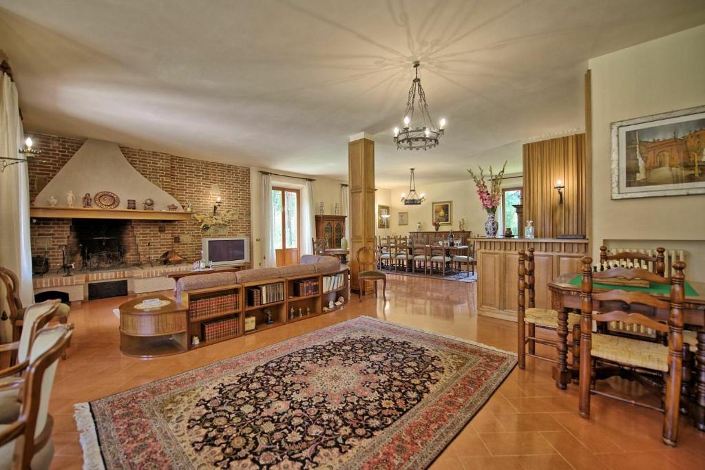un grand salon avec une table et une cheminée dans l'établissement Villa Lauretana by PosarelliVillas, à Torrita di Siena