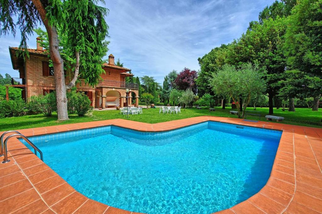 une piscine devant une maison dans l'établissement Villa Lauretana by PosarelliVillas, à Torrita di Siena
