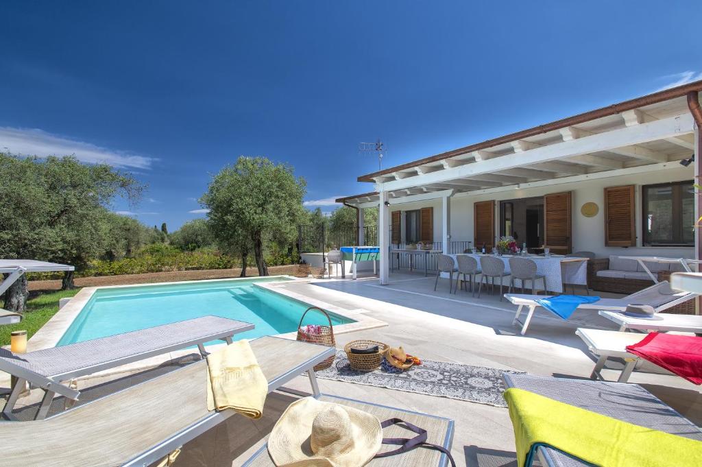 Cette villa dispose d'une piscine et d'une terrasse. dans l'établissement Villa Olivetta con piscina, à Alghero