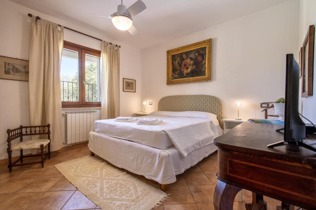 - une chambre avec un lit, une télévision et un piano dans l'établissement Villa Olivetta con piscina, à Alghero 37 autres photos