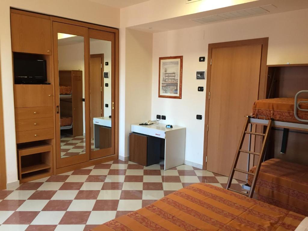 une chambre avec un lit, un lavabo et un miroir dans l'établissement Hotel Fiorella, à Senigallia