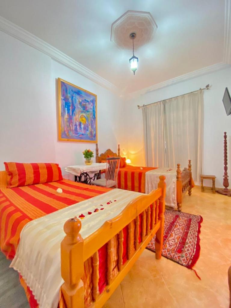 une chambre avec deux lits et un canapé dans l'établissement Dar Baddi, à Marrakech