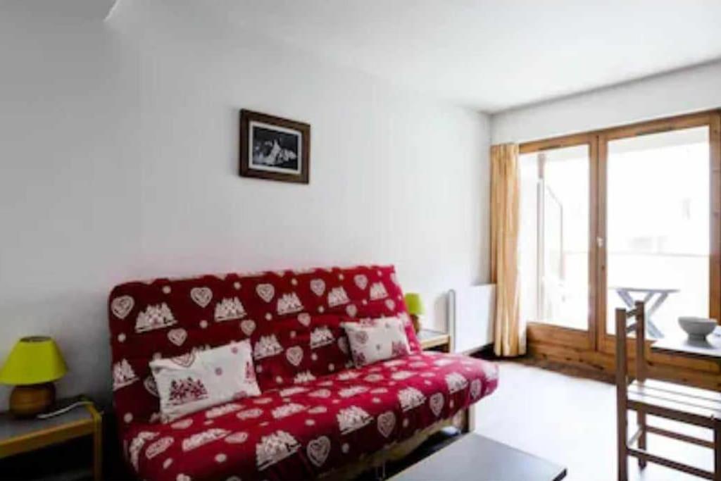 - un salon avec un canapé rouge et une fenêtre dans l'établissement Studio Grand Chalet hyper centre, à Brides-les-Bains