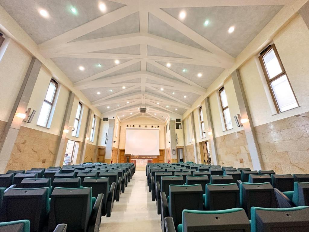 une salle de conférence vide avec des chaises et un écran dans l'établissement Villa MG Hotel, à Santa Marinella