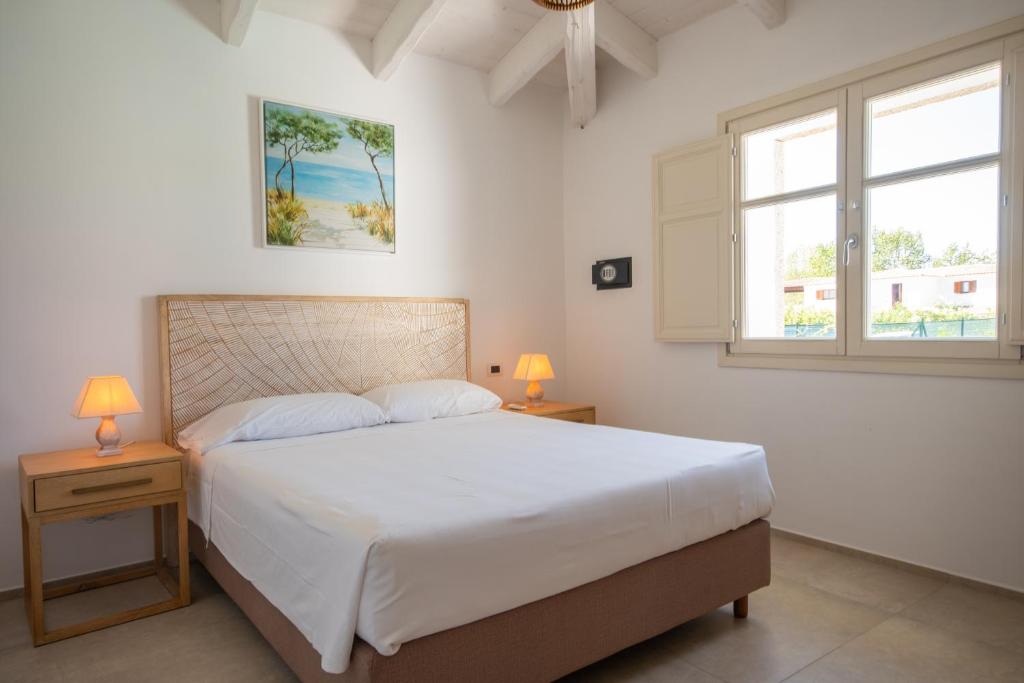 - une chambre avec un grand lit, 2 tables et 2 fenêtres dans l'établissement Capannizza Villas, à Budoni