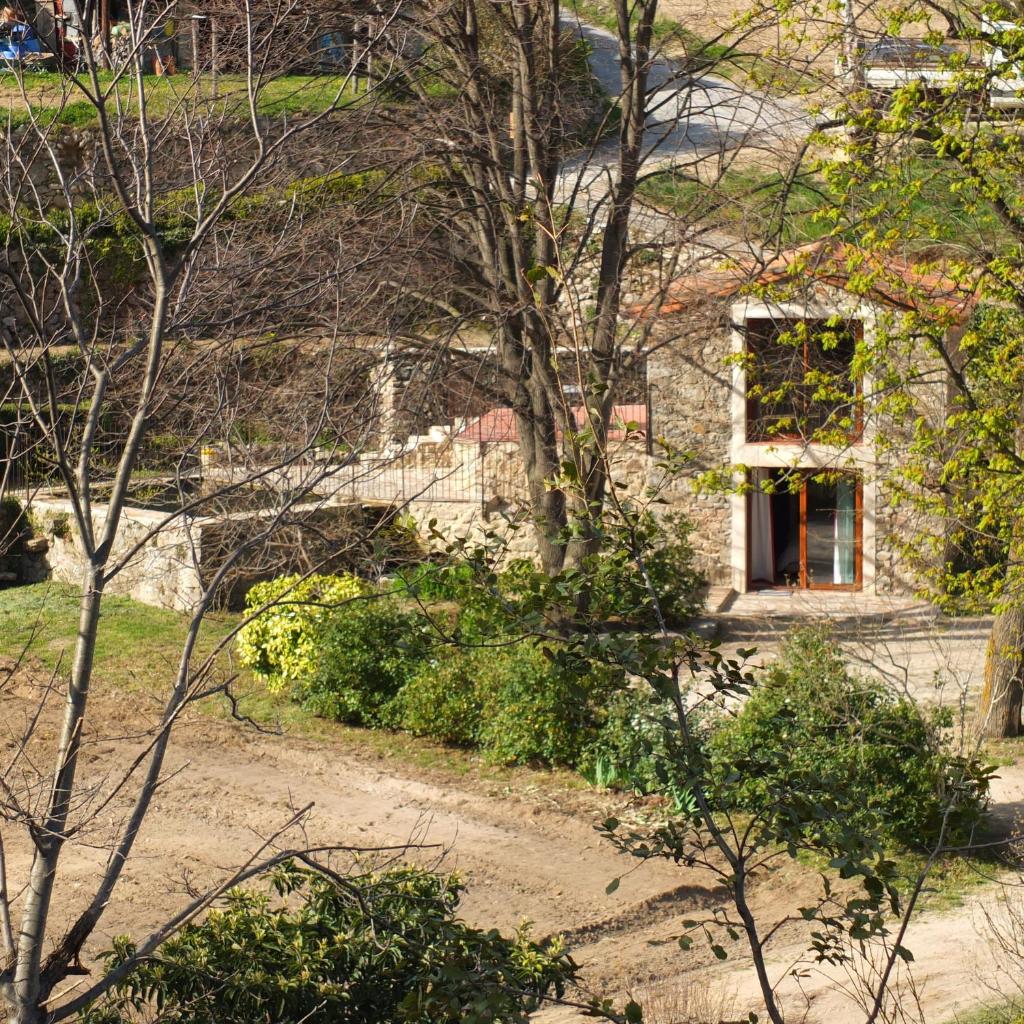 une maison en pierre avec une fenêtre et quelques arbres dans l'établissement Gite Mas Des Combes, à Mandagout