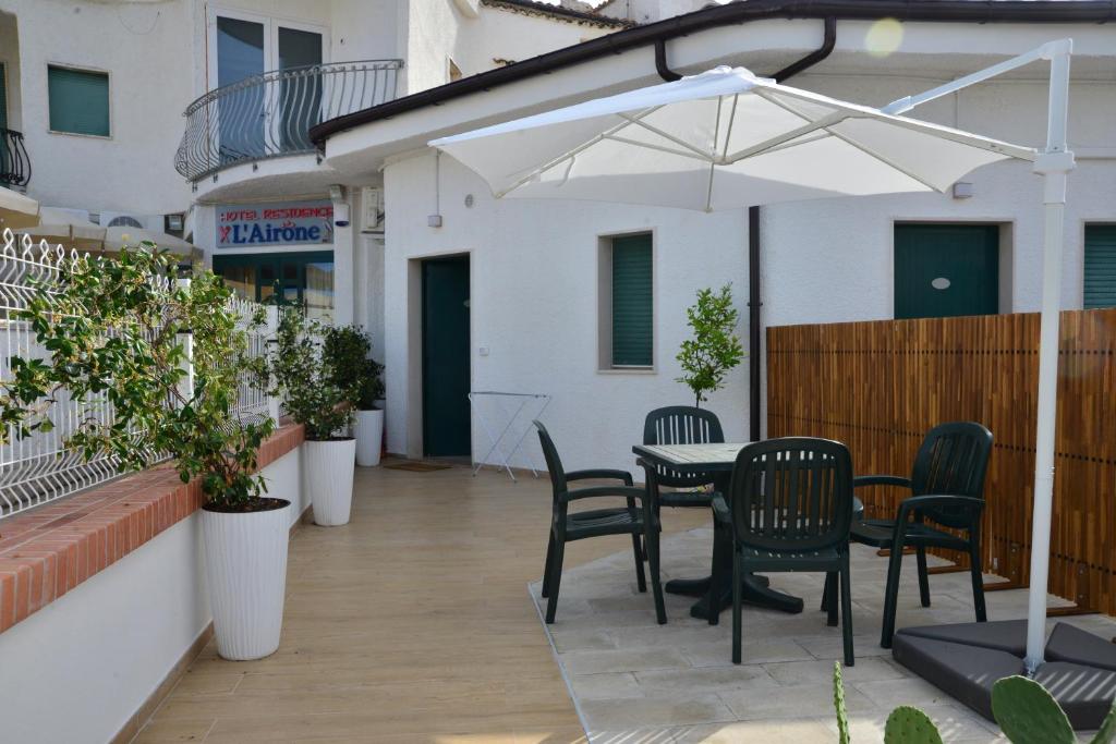 un patio avec une table, des chaises et un parasol dans l'établissement Residence Airone, à Termoli
