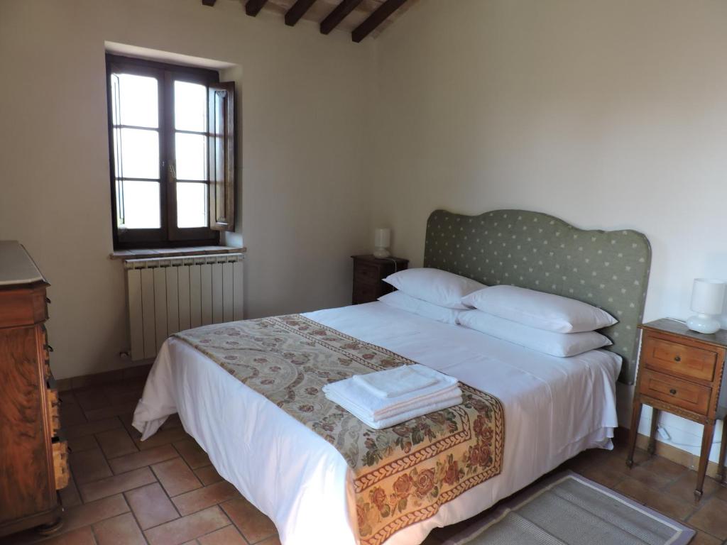 une chambre avec un lit avec des draps blancs et une fenêtre dans l'établissement Villa Bellavista - Piscina ad uso esclusivo, à Celle sul Rigo