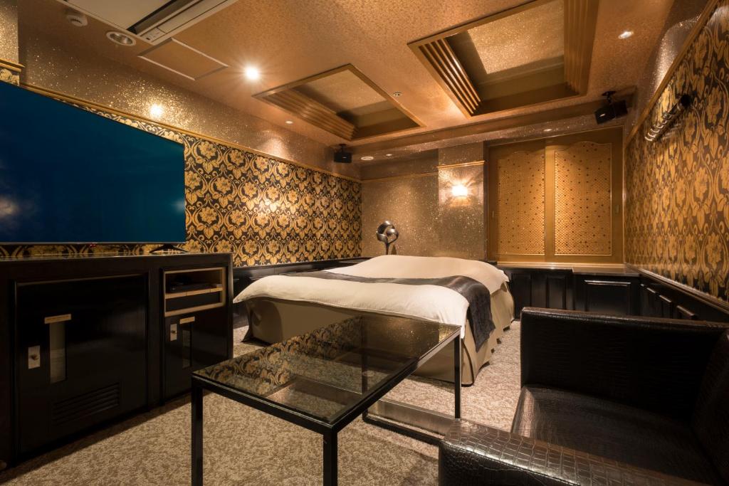 une chambre avec un lit et une télévision à écran plat dans l'établissement ホテル ジェムジェム 十三, à Osaka