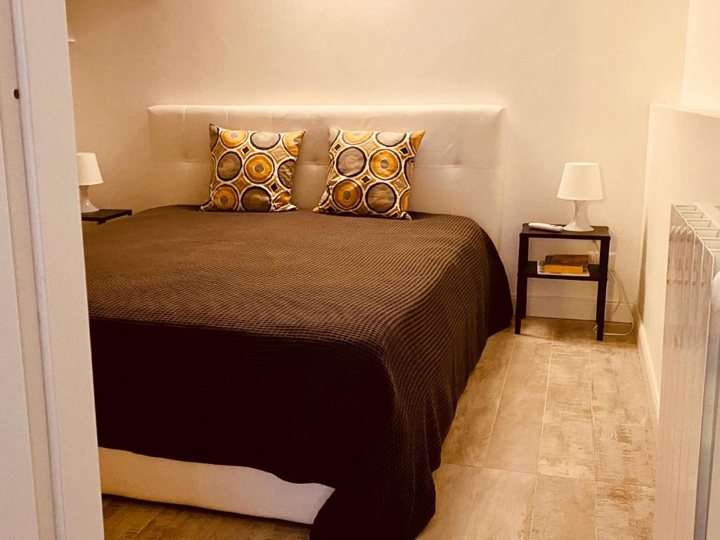 une chambre avec un lit avec des oreillers et deux lampes dans l'établissement flAle's holiday house, à Cefalù