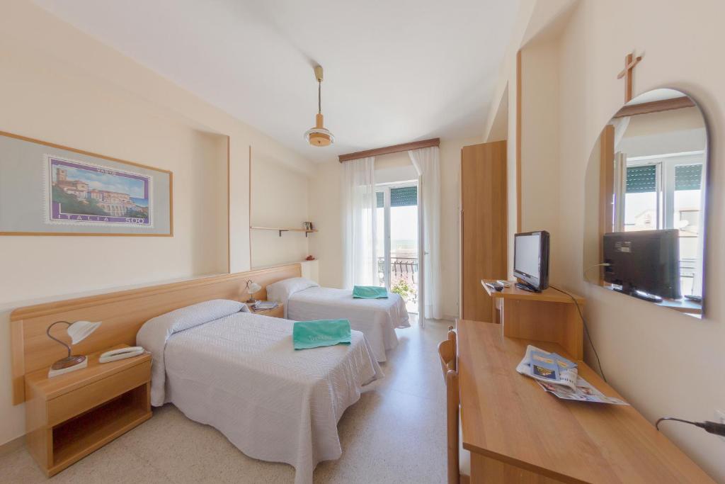 une chambre d'hôtel avec deux lits et une télévision dans l'établissement Hotel Venezia New, à Vasto