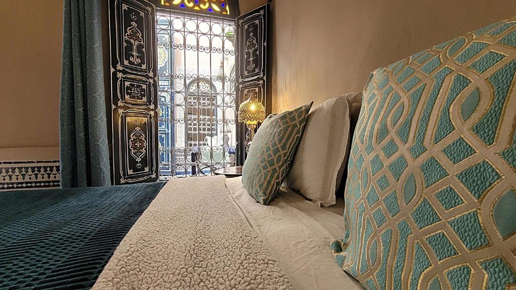 une chambre avec un lit et un vitrail dans l'établissement Riad Dar Alma Fes, à Fès