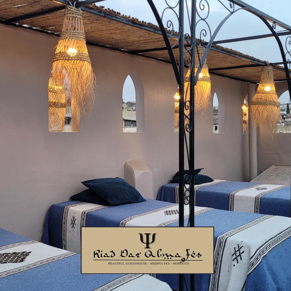 - un groupe de lits dans une chambre avec éclairage dans l'établissement Riad Dar Alma Fes, à Fès