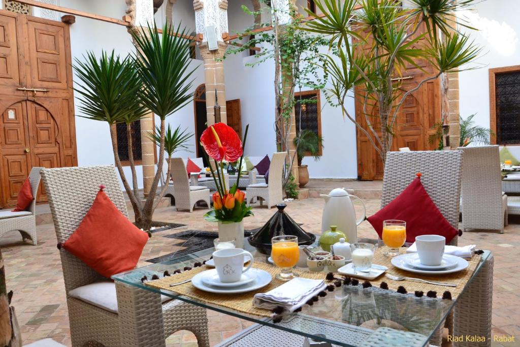 - une table avec des chaises et des boissons sur la terrasse dans l'établissement Riad Kalaa, à Rabat