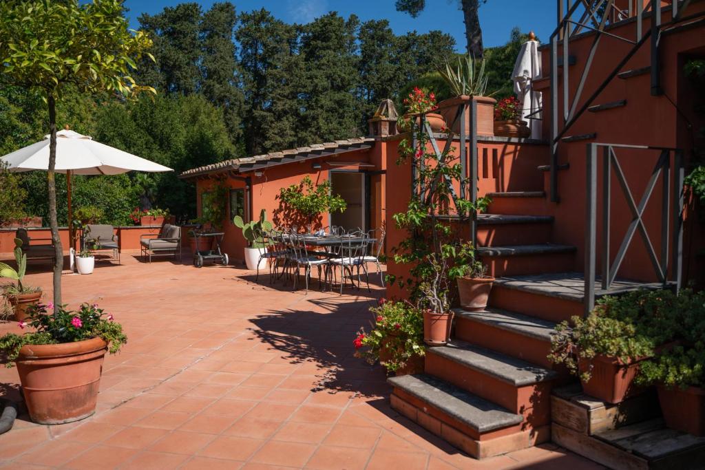 une terrasse avec des escaliers, une table et un parasol dans l'établissement Villa Terme di Caracalla with private Swimming Pool, à Rome