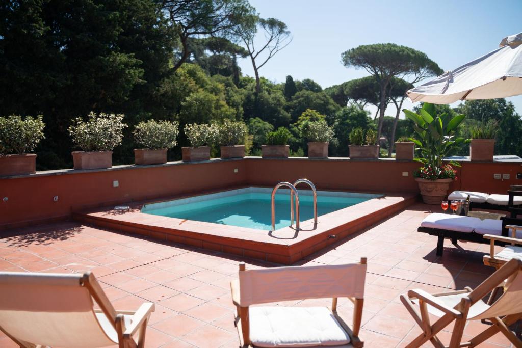 une piscine dans un patio avec des chaises et un parasol dans l'établissement Villa Terme di Caracalla with private Swimming Pool, à Rome