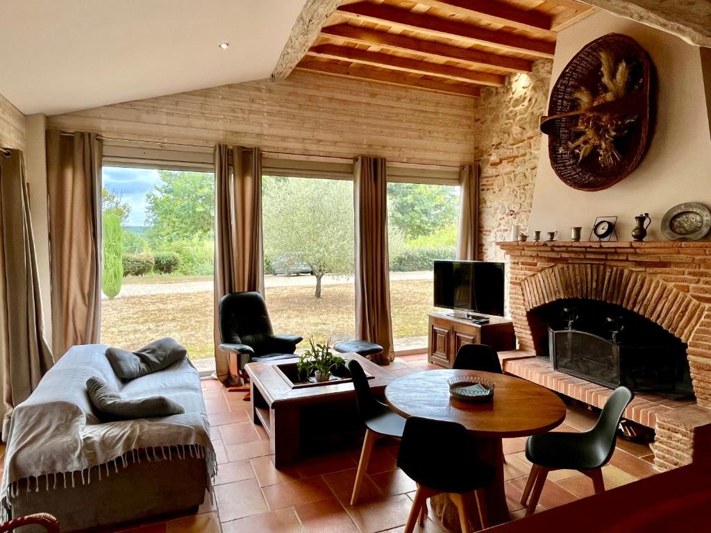 un salon avec un canapé et une cheminée dans l'établissement Gite Le Mas De Marie, à Lavaur